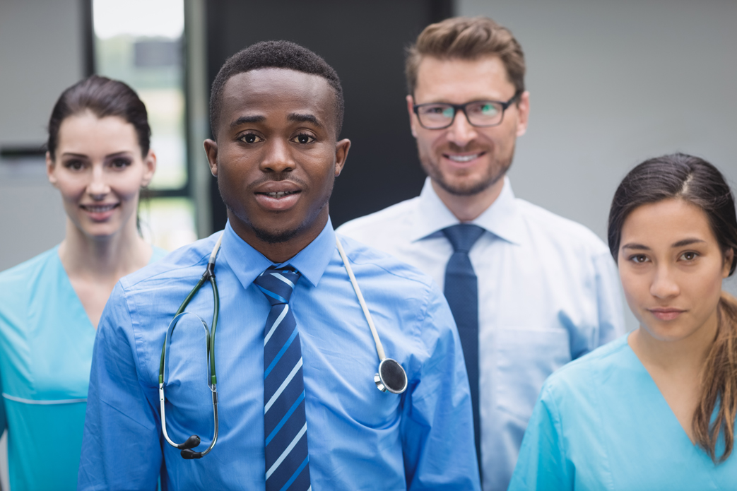 smiling-medical-team-standing-together-hospital-corridor